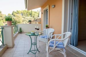 a patio with a table and chairs on a balcony at Solari Hill Maisonette two private parking in Corfu