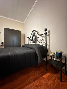 a bedroom with a black bed and a table at La Via del Mare in Torre del Greco