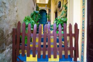 une clôture en bois devant une maison avec une porte dans l'établissement Soham Haveli Udaipur, à Udaipur