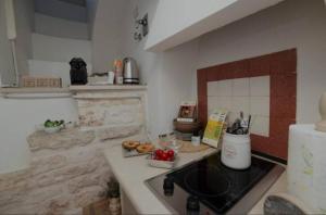a kitchen with a stove and a counter with food on it at Saymon's Suite in Ceglie Messapica