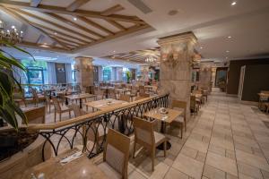 a restaurant with tables and chairs in a room at Maritim Antonine Hotel & Spa in Mellieħa