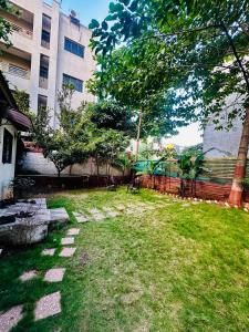 a grass yard with a bench and a building at Farmhouse in Pune city in Pune