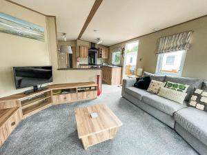 a living room with a couch and a coffee table at Beautiful 6 Berth Caravan At Caldecott Hall Country Park, Norfolk Ref 91150c in Great Yarmouth