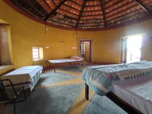 Habitación con 2 camas y mesa. en Jodhpur Farms en Jodhpur
