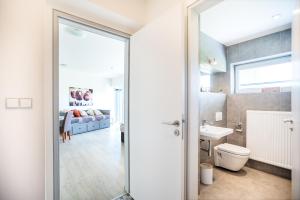 Apartmán Lamba Klínovec في لويكنا بود كلينوفسيم: حمام مع مرحاض ومغسلة وغرفة نوم +21 صورة