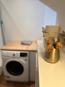 een vaas met bloemen op een toonbank naast een magnetron bij Beautiful Studio in the Heart of Salzburg in Salzburg