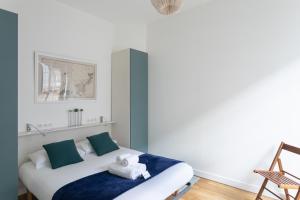 a bedroom with a bed with a blue blanket at Le Solent - Au cœur de l'intra-mutros in Saint Malo