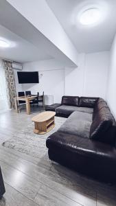un soggiorno con divano in pelle e tavolo di Apartament Dem Radulescu 3 camere! a Râmnicu Vâlcea