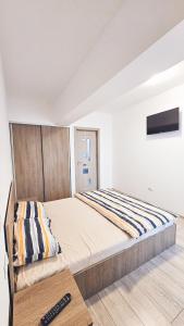 a bedroom with a large bed and a remote control at Apartament Dem Radulescu 3 camere! in Râmnicu Vâlcea