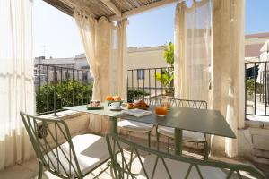 a green table and chairs on a balcony with a window at Palazzo Muci in Nardò