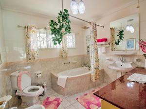 a bathroom with a tub and a toilet and a sink at 360 Degrees Villa in Victoria