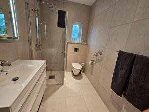 een badkamer met een douche, een toilet en een wastafel bij Family Wildlife Experience 3 BR House in Uddevalla