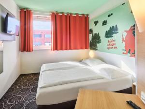 - une chambre avec un lit blanc et une fenêtre dans l'établissement B&B Hotel Aschaffenburg, à Aschaffenbourg