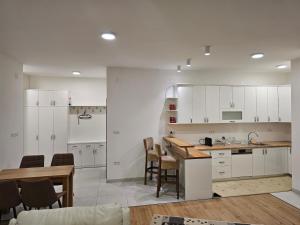 a kitchen with white cabinets and a table and chairs at Apartman Teo Banja Luka in Banja Luka