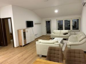 ein Wohnzimmer mit weißen Möbeln und einem Flachbild-TV in der Unterkunft Apartman Teo Banja Luka in Banja Luka