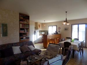 ein Wohnzimmer mit einem Sofa und einem Tisch in der Unterkunft Meschers sur Gironde - MAISON SPACIEUSE au CALME avec BEAU JARDIN ARBORE in Meschers-sur-Gironde
