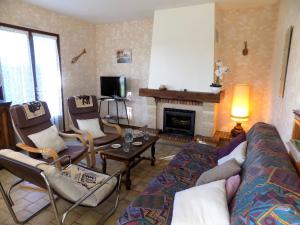ein Wohnzimmer mit einem Sofa, Stühlen und einem Kamin in der Unterkunft Meschers sur Gironde - MAISON SPACIEUSE au CALME avec BEAU JARDIN ARBORE in Meschers-sur-Gironde