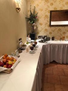 una larga mesa blanca con un tazón de fruta. en Willmersdorfer Hof, en Cottbus