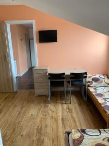 a room with a desk and a bedroom with two beds at APARTAMENTY OLIWIA Łeba Bałtycka in Łeba