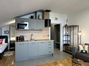 a kitchen with white cabinets and a living room at Sana Ski apartment 702 in Flora, Borovets in Borovets