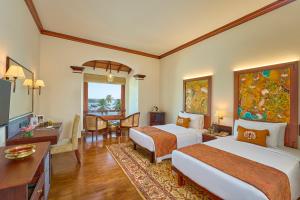 Una habitación de hotel con dos camas, un escritorio y una mesa. en The Leela Ashtamudi, A Raviz Hotel, en Kollam 155 fotos más