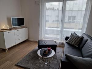 a living room with a couch and a tv at Auszeit Penthouse-Feeling in Esslingen
