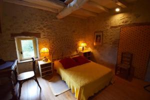 1 dormitorio con cama, escritorio y ventana en Maison de caractère à Castella - Clévacances 3 clés, en Castella