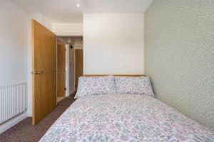 1 dormitorio con 1 cama y puerta de madera en Seafront flat- Private parking- Close to town en Weston-super-Mare