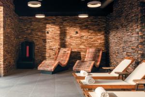 szereg krzeseł w pokoju z ceglaną ścianą w obiekcie Grund Resort Golf and Ski w Mladych Bukach