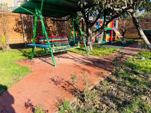 a park with a bench and a playground at BioLocalia House Bucovina in Baloteşti