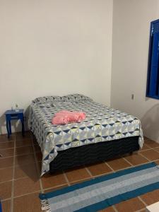 ein Bett mit zwei rosa Klamotten auf einem Zimmer in der Unterkunft Céu azul in Vera Cruz de Itaparica