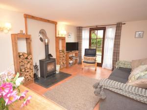 a living room with a couch and a wood stove at 2 Bed in Dartmoor National Park 63337 in Spreyton