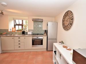 a kitchen with white appliances and a clock on the wall at 2 Bed in Dartmoor National Park 63337 in Spreyton