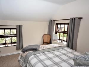 a bedroom with a bed and two windows at 2 Bed in Dartmoor National Park 63337 in Spreyton