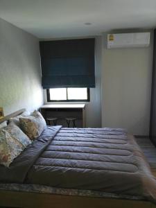 Schlafzimmer mit einem großen Bett und einem Fenster in der Unterkunft The Beach Residence by EHM in Nai Yang Beach