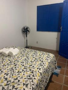 ein Schlafzimmer mit einem Bett mit einer schwarzen und gelben Decke in der Unterkunft Céu azul in Vera Cruz de Itaparica