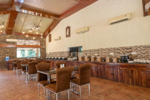 a bar with chairs and tables in a restaurant at The Roar Resort in Rāmnagar