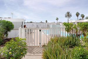 einen weißen Zaun vor einem weißen Gebäude in der Unterkunft Bungalow Aloe Dunas 2 in Maspalomas