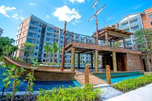 a building with a boat in front of a building at The Beach Residence by EHM in Nai Yang Beach