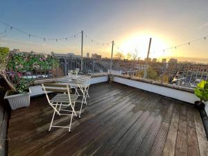 a balcony with a table and chairs on a roof at Modern with Stylish Terrace - Your London Oasis! in London