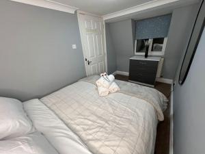 a bedroom with a bed with two pairs of shoes on it at Modern with Stylish Terrace - Your London Oasis! in London