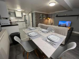 a dining room and kitchen with a table and chairs at Modern with Stylish Terrace - Your London Oasis! in London