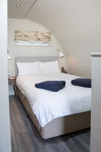 1 cama con 2 toallas en un dormitorio en Sauchope Links Holiday Lodge and Glamping Park, en Crail