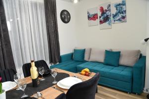 a living room with a blue couch and a table at Sky Lux Apartments in Jahorina