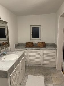 ein weißes Badezimmer mit einem Waschbecken und 2 Spiegeln in der Unterkunft Oberneulander Gästehaus in Bremen
