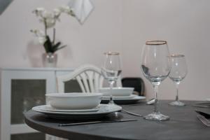 a table with two wine glasses and a bowl on it at Hurrell House in Boreham