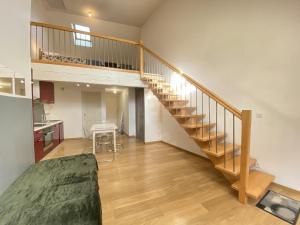 a living room with a staircase and a kitchen at Le Duplex Ruthenois, Rodez centre in Rodez