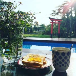 a table with a plate of toast and a cup of coffee at Baan mansin บ้านม่านศิลป์ in Pak Chong