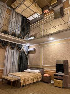 um quarto com uma cama e uma televisão num quarto em Vodnik Hotel em Semey