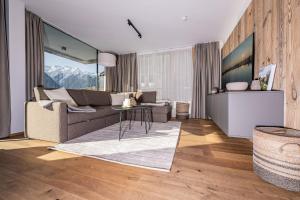 uma sala de estar com um sofá e uma mesa em Modern Apartment with Panoramic View em Neukirchen am Grossvenediger